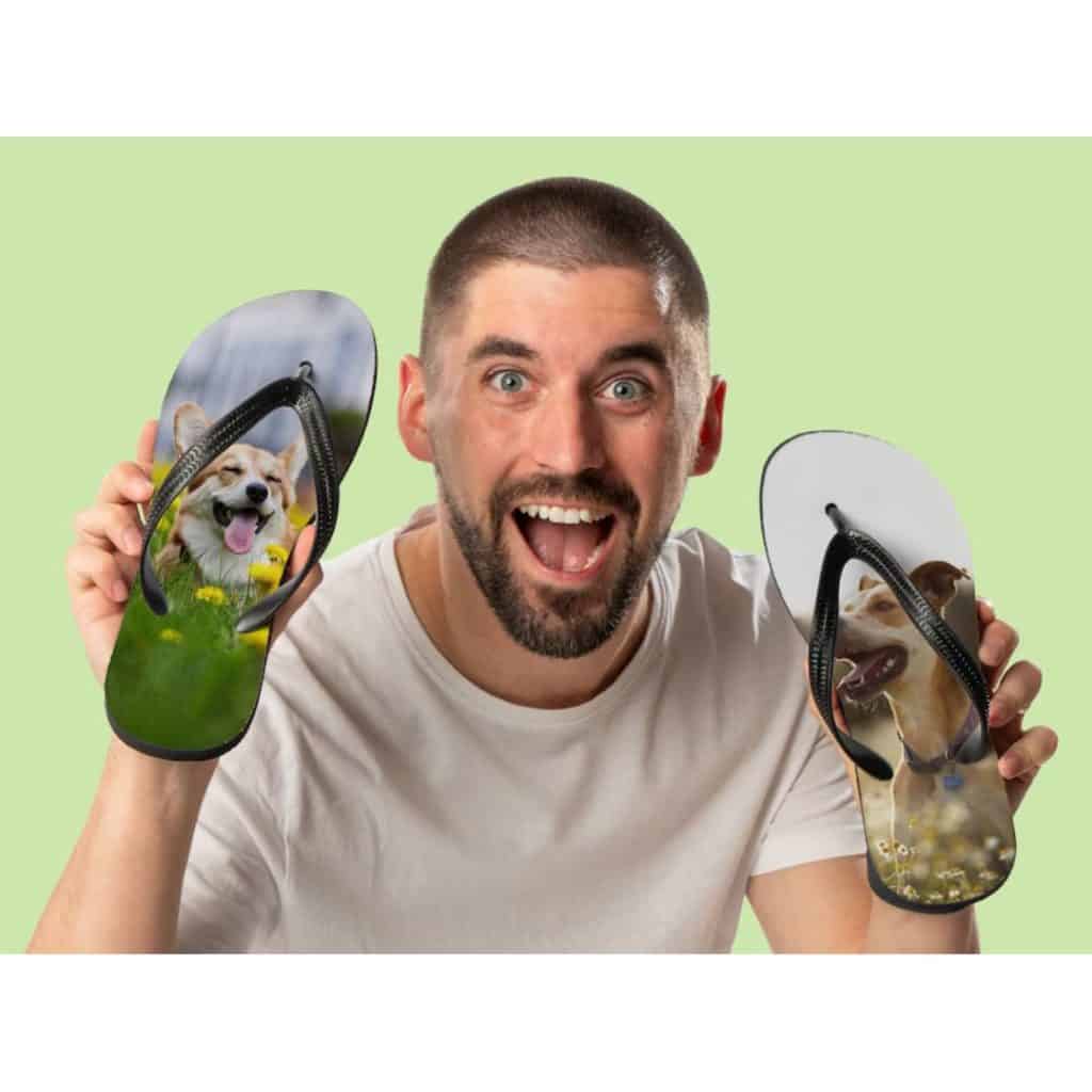 En man håller upp två flip-flops med personliga foton på hundar tryckta på sulorna.