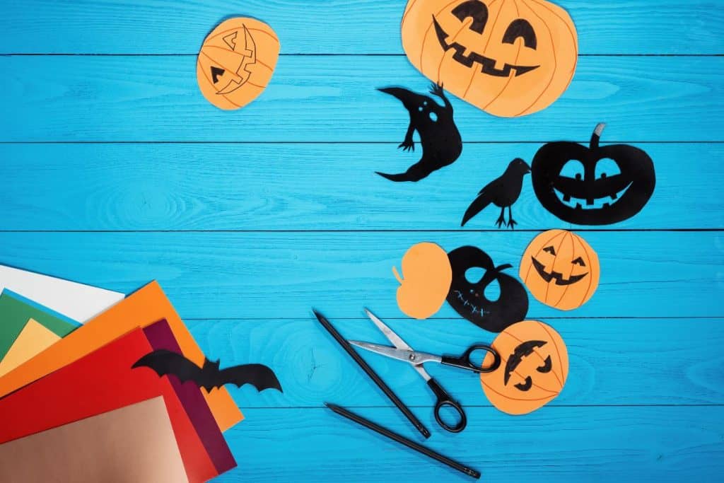 Barnpyssel med utklippta halloween-prylar, pumpor, med mera