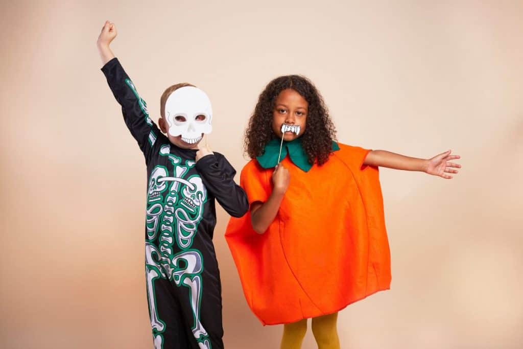 Barn utklädda till pumpa och skelett på halloween