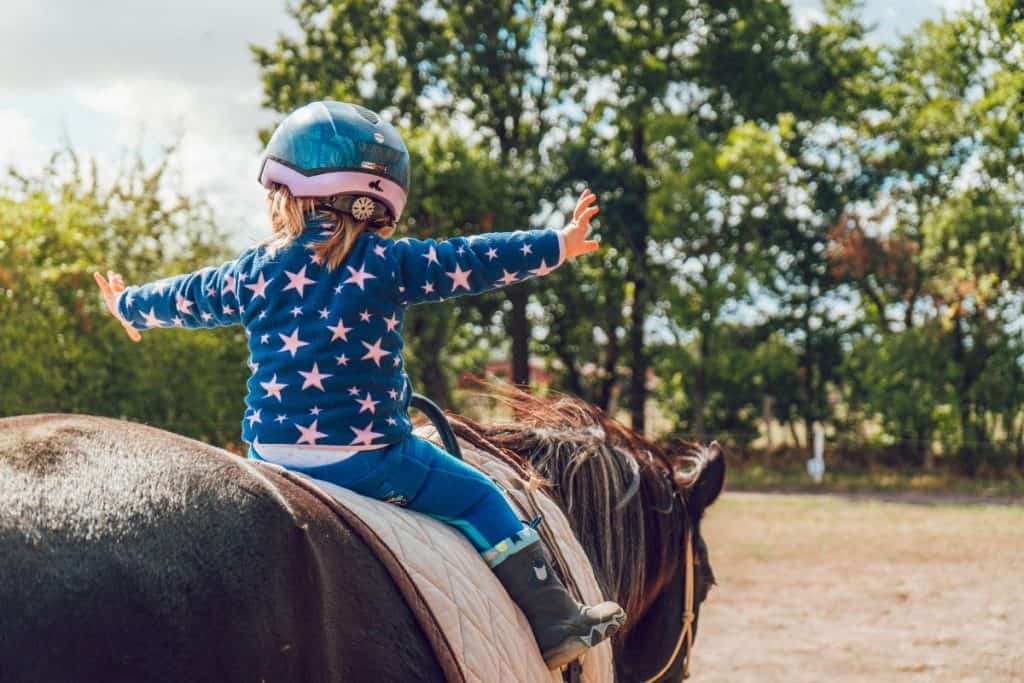 Flicka sitter på häst