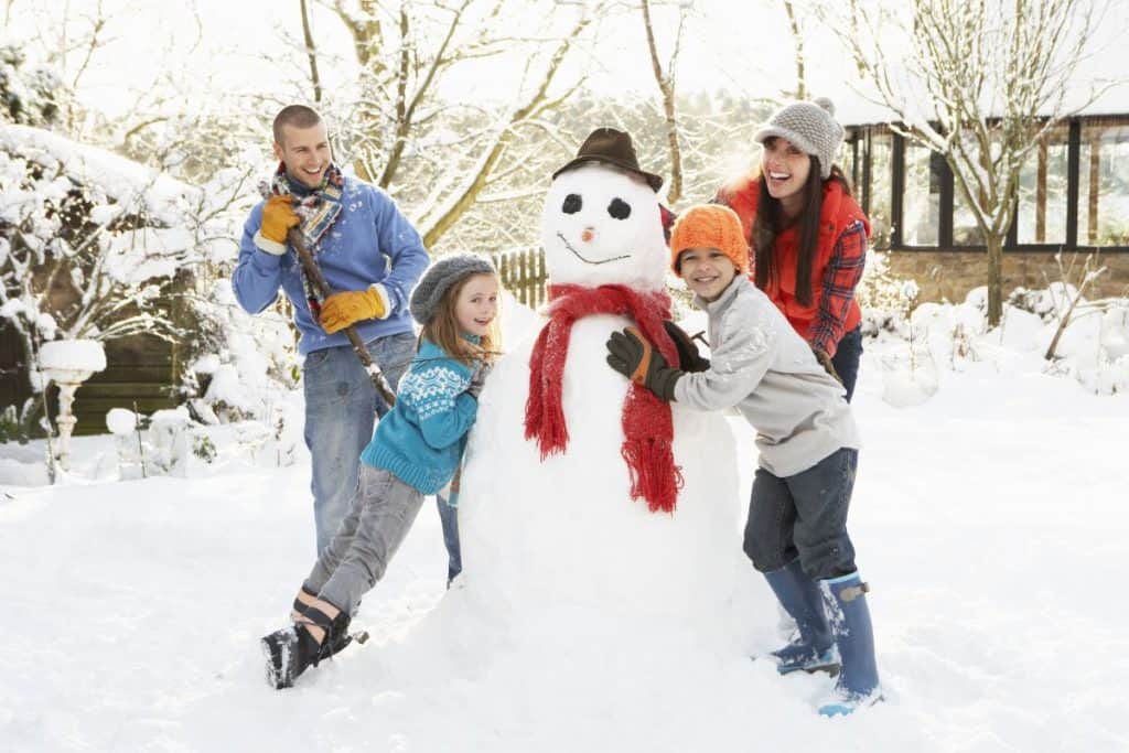 familj bygger snögubbe