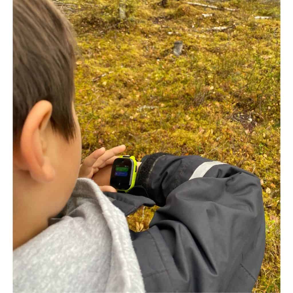 Barn med GPS-klocka i skogen