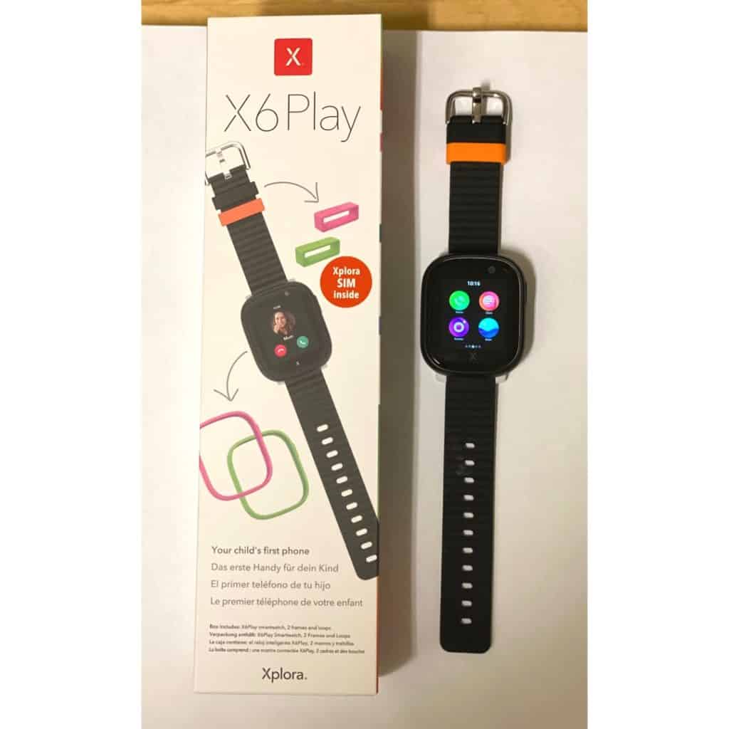 Xplora X6Play klocka svart med orange detaljer, bredvid originalkartong på ett bord